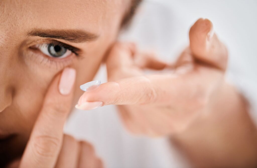 Someone putting a contact lens into their eye.