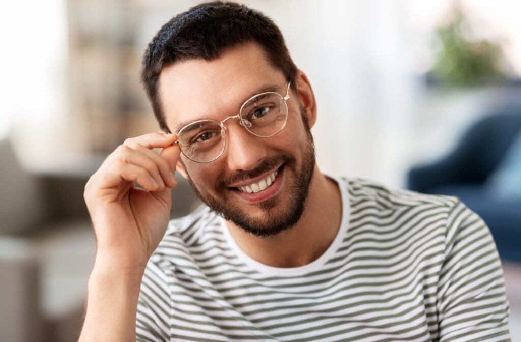 A person wearing thin wire framed glasses that compliment their face shape