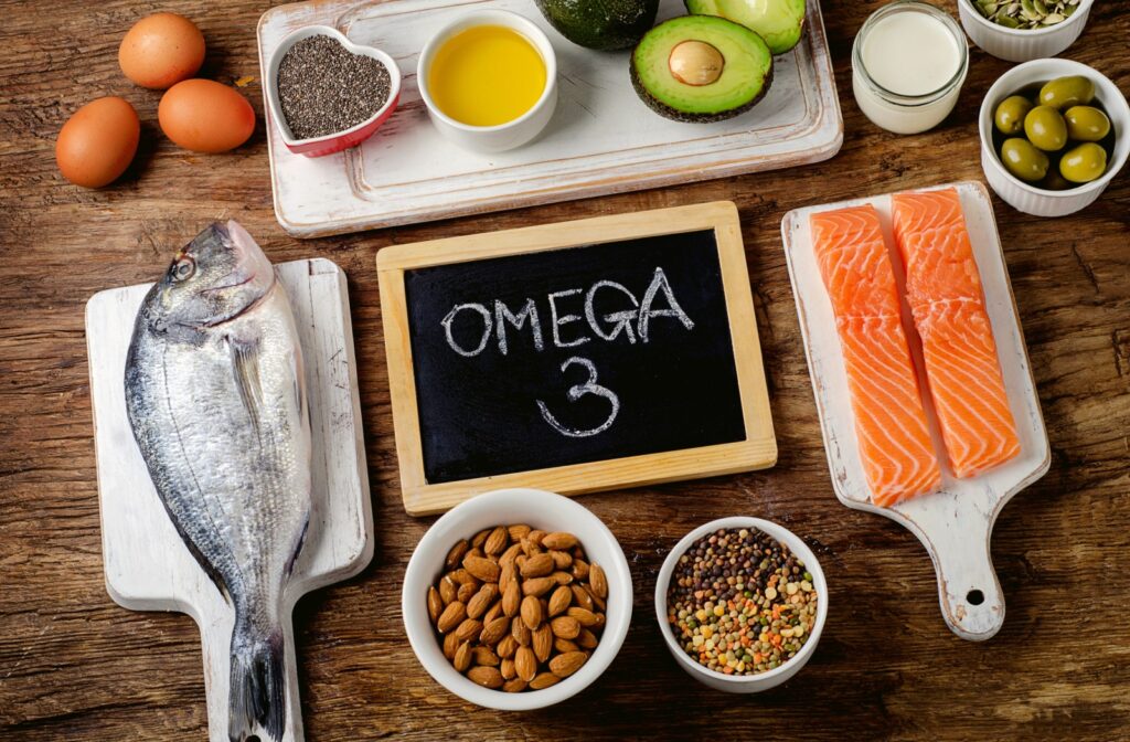 A variety of foods that are high in omega 3 fatty acids such as salmon, eggs, and olives.