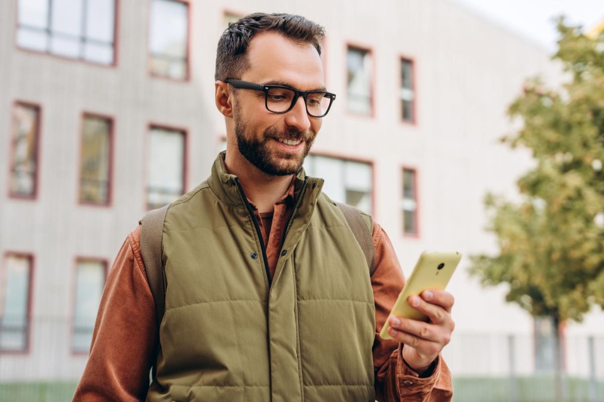a person wearing glasses while they look at their phone